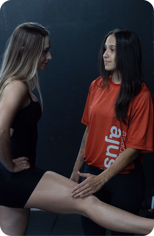 Professora da Academia Ajuste acompanhando aluna iniciante no treino
